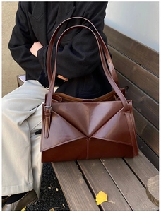Dettaglio macro della borsa tote in pelle cerata marrone con design geometrico