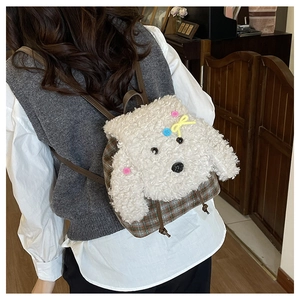 Dettaglio dello zaino in peluche a forma di cane bianco con tessuto scozzese e cinghie