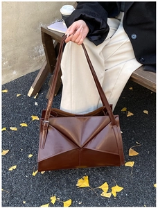 Dettaglio della borsa tote marrone cioccolato con design geometrico e tracolla regolabile
