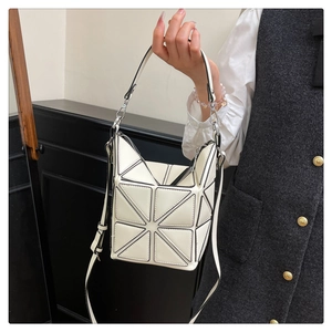 Close-up of white geometric panel bucket bag with architectural triangle stitching