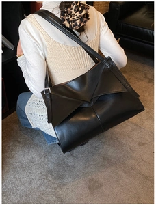 Dettaglio della capiente borsa nera con piega origami e tracolla ampia regolabile
