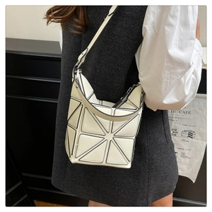 Detailed view of a white geometric panel bucket bag with glossy 3D triangular pattern