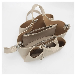 Detail view of the multi-compartment interior and lychee grain texture of the beige tote bag