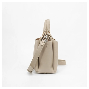 Détail du sac seau en cuir grainé beige avec ferrures argentées et plis sur le côté