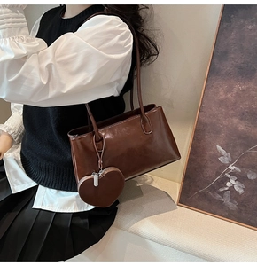Detail of dark brown vintage shoulder bag with heart-shaped coin purse and smooth finish