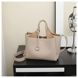 Chic beige lychee grain bucket bag with silver ring detail and adjustable shoulder strap