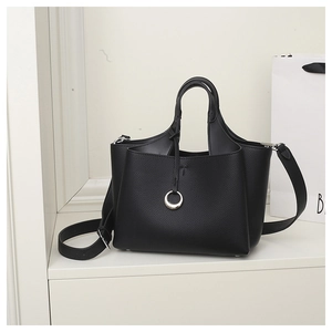 Close-up of black lychee-grain bucket bag with silver metal ring and sleek top handle