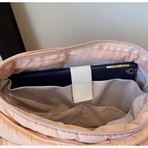 Detail view of pink quilted tote bag interior with tablet slot and organized pockets