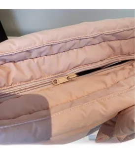Detailed macro view of a smooth SBS zipper on a pink quilted nylon tote bag
