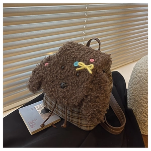 Dettaglio dello zaino a forma di cucciolo in peluche con texture sherpa e motivo tartan