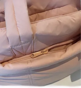 Close-up of the smooth SBS zipper and quilted puffer fabric on a pink tote bag