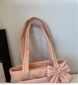 Pink quilted tote bag detail with large decorative bow and padded comfortable handles