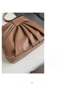 Detail view of large brown pleated leather tote bag with soft texture for daily commuting
