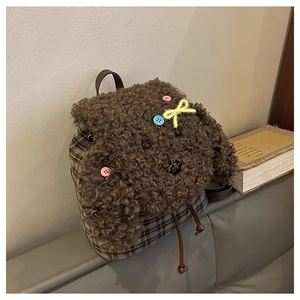 Dettaglio di uno zainetto a forma di cane in peluche con tessuto a quadri grigi e coulisse