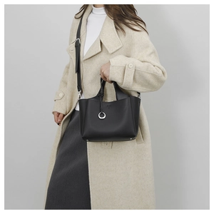 On-body view of black grained leather tote bag with silver ring and shoulder strap