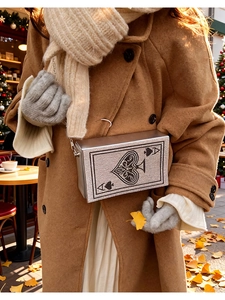 Détail du sac de soirée argenté avec motif As de Pique en cristaux sur fond d'automne