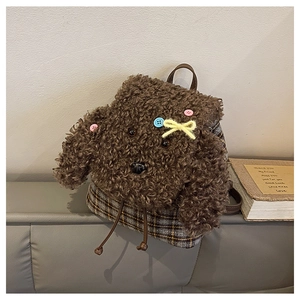 Dettaglio dello zainetto a cucciolo in pile sherpa marrone e base in tessuto plaid