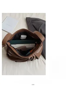 Detail view of large capacity brown leather tote bag showing organized interior and pleats