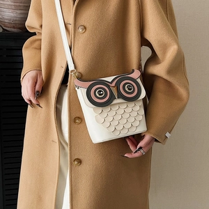 Quirky owl-shaped white leather crossbody bag with feather-textured layers and large eyes
