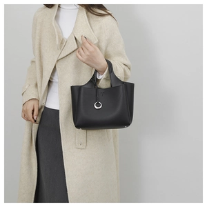 Detail shot of a black litchi grain leather handbag with silver ring buckle ornament
