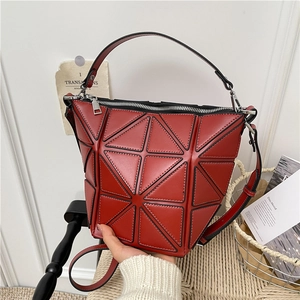 Modern red geometric bucket bag with black triangular panels and top handle strap