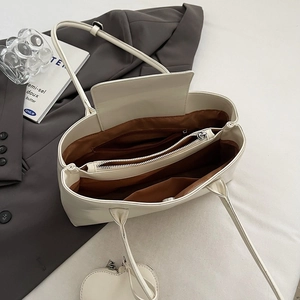 Minimalist white leather tote bag with interior compartments and heart charm for office