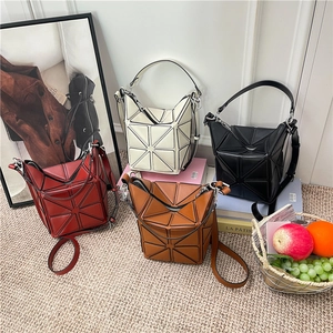 Geometric paneled bucket bags in red white black and brown with crossbody straps