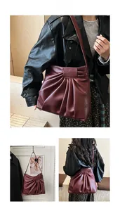 Close-up of wine red pleated tote bag with wide shoulder strap and spacious interior