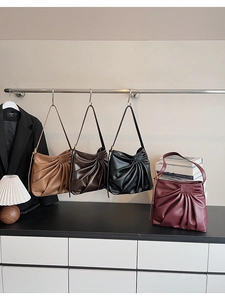 Detail of pleated faux leather tote bags in four classic colors for daily commute