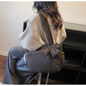Detailed view of the large quilted dark coffee tote bag with a bow accent and soft texture