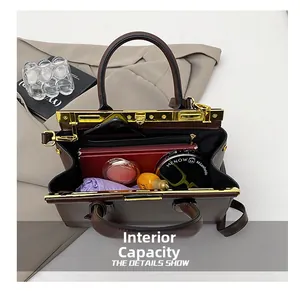 Macro shot of the interior capacity of a dark brown leather handbag with gold frame closure