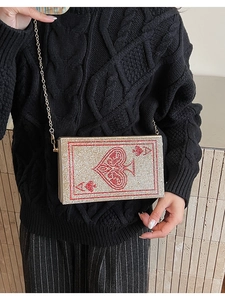 Close-up of luxury Ace of Spades evening clutch with crystals and gold chain strap