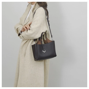 Close-up of litchi grain leather tote with silver ring detail and adjustable shoulder strap