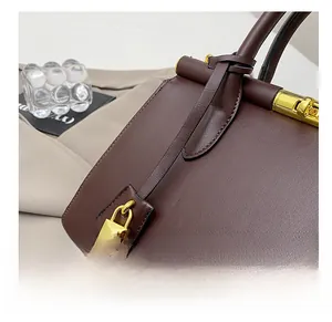Close-up of premium brown leather handbag with luxury gold buckle and lychee grain texture