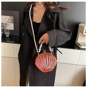 Detail of shell-shaped acrylic bag featuring gradient pink beads and pearl crossbody strap