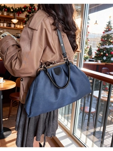 Détail du sac médecin vintage en toile bleu marine avec poignées en cuir dans un café