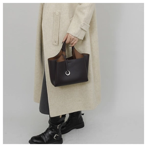 Detail of dark brown lychee leather tote bag with silver ring and embossed T logo
