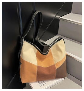 Detail of color-block tote bag with suede texture and contrast stitching on the shoulder strap