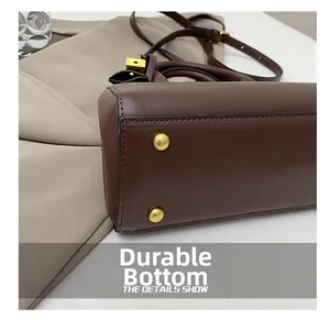 Detailed macro view of dark brown leather handbag base with protective gold metal studs