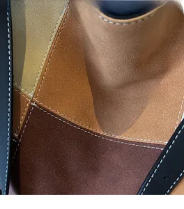 Detail of stitched vintage tote bag with mixed brown and black suede material layers