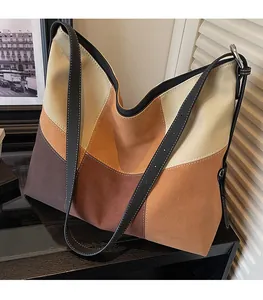 Detail of color-block tote bag with slim black leather shoulder straps and fine stitching