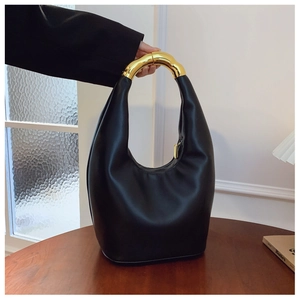 Dettaglio borsa hobo in pelle nera con manico circolare dorato e finitura pregiata
