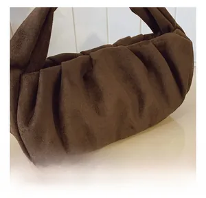 Macro shot of vintage brown suede leather texture on pleated underarm shoulder bag