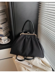 Détail du sac bandoulière plissé noir avec fermoir métallique vintage et poignée
