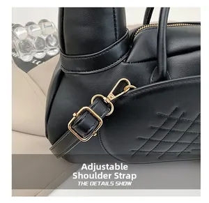 Détail du sac en cuir matelassé noir avec bandoulière réglable et boucle dorée