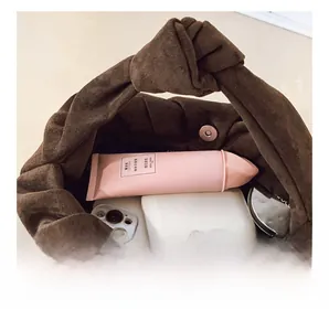 Detail of the brown ruched cloud bag showing the interior space and magnetic clasp closure