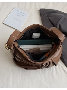 Macro view of interior storage space and zipper detail of pleated leather bucket bag