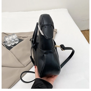 Vue détaillée du sac en forme de canard noir montrant la texture du cuir PU de qualité
