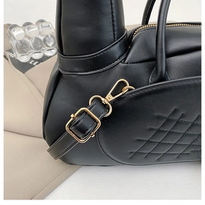 Détail du sac en cuir noir mat avec matelassage en losanges et ferrures en métal doré