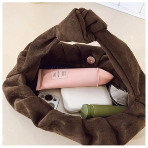 Interior view of brown suede cloud bag showing magnetic closure and storage capacity